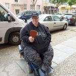 junge Frau im Rollstuhl freut sich über neue Brille