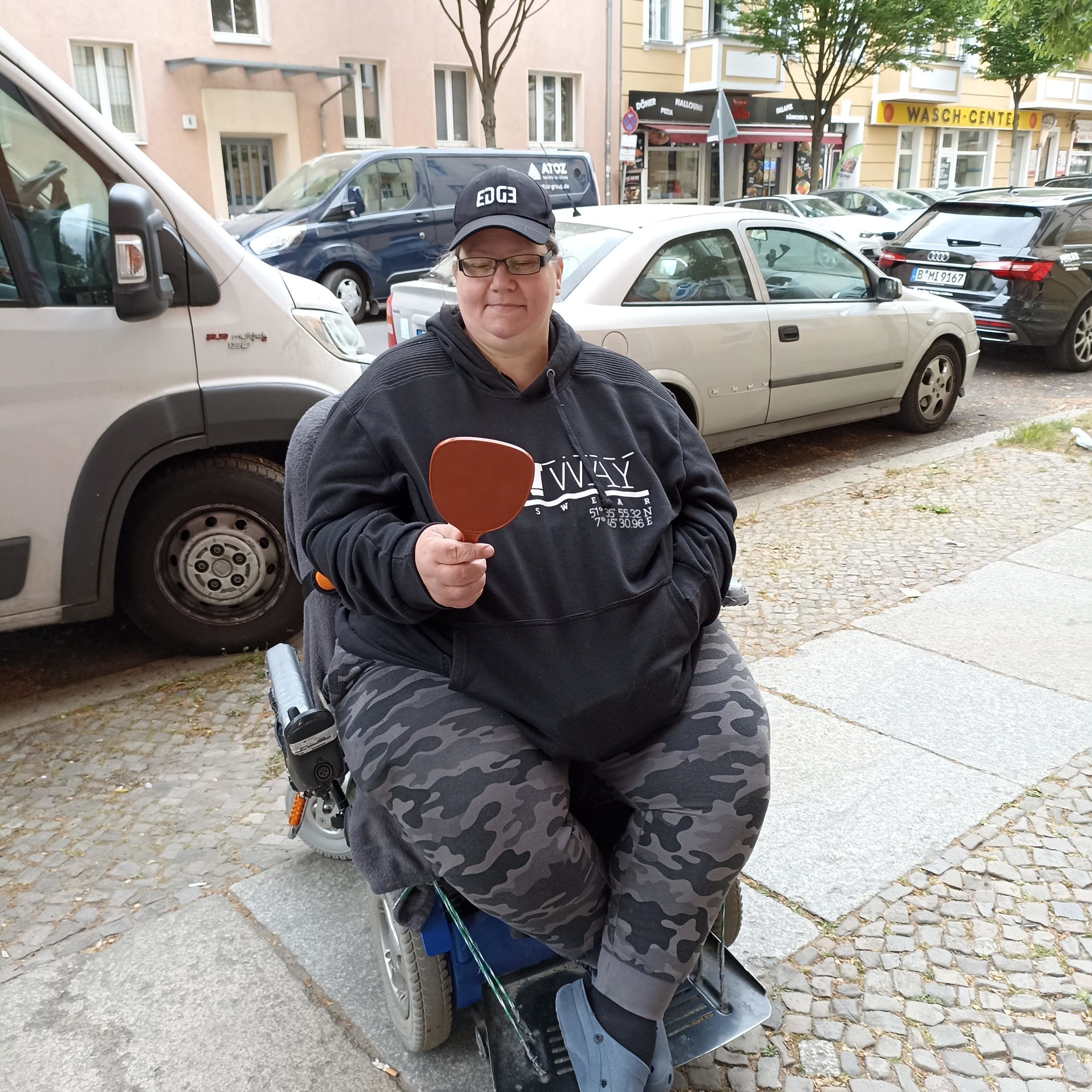 junge Frau im Rollstuhl freut sich über neue Brille