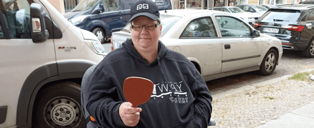 Eine junge Frau im Rollstuhl freut sich über ihre neue Brille von M